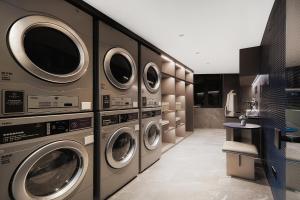 a laundry room with four washer and dryer machines at Atour Light Hotel Chongqing Yuzhong Daping Metro Station in Chongqing