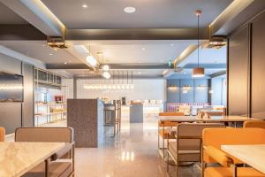 a restaurant with tables and chairs and a bar at Atour Hotel Shanghai Caohejing in Shanghai