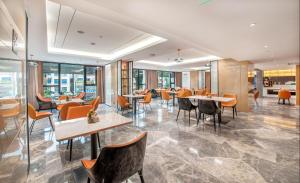 a restaurant with tables and chairs and windows at Atour Hotel Guangzhou Sanyuanli in Guangzhou