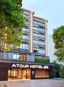 un bâtiment de quatre hôtels avec un panneau d'hôtel devant lui dans l'établissement Atour Hotel Chengdu Jinli Hongpailou Subway Station, à Chengdu