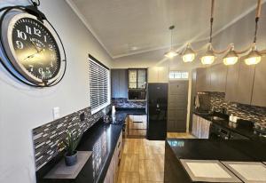 a kitchen with a large clock on the wall at De Oude Sleeper Inn 3 in Kimberley