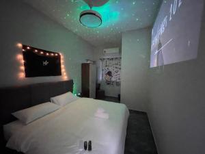 a bedroom with a white bed with lights on the ceiling at Room with PrivateBathroom, Projector, KSL Mall in Johor Bahru