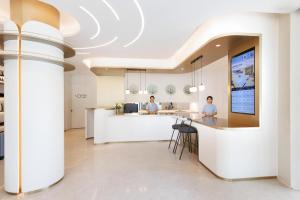 two people sitting at a counter in a kitchen at Atour Light Hotel Shanghai Lujiazui Financial Center in Shanghai