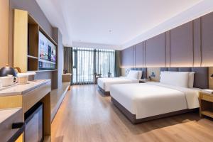 a hotel room with two beds and a television at Atour X Hotel Beijing Majiabao Subway Station in Beijing