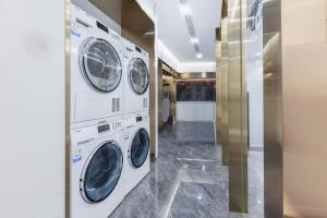 a laundry room with three washer and dryer at Atour Light Hotel Beijing Daxing Biomedical Base Metro Station in Daxing