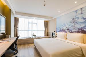 a hotel room with a large bed and a desk at Atour Hotel Kunming Dashanghui in Kunming