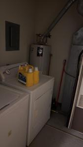 een wasruimte met een wasmachine en een koelkast bij CCS LLC in Champaign
