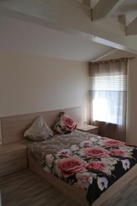 una camera da letto con un letto fiorito di Apartamentai Vilma a Palanga
