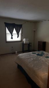 a bedroom with a bed and a window with curtains at CCS LLC in Champaign