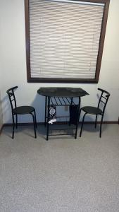 een tafel en 2 stoelen in een kamer met een raam bij CCS LLC in Champaign
