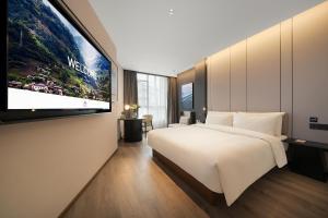 a bedroom with a large bed and a flat screen tv at Atour Hotel Chongqing Bishan CBD Financial Street in Daxing +47 photos
