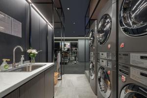 a laundry room with multiple washing machines and a sink at Atour Hotel Foshan Chancheng Zhangcha in Foshan