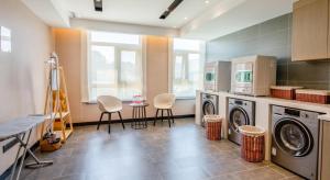 a laundry room with two washing machines and two chairs at Atour Hotel Xi'an West Erhuan Road Tai'ao in Xi'an
