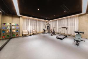 ein Zimmer mit einem Fitnessraum mit Laufband und Trainingsgeräten in der Unterkunft Atour Hotel Guangzhou Panyu City Bridge in Guangzhou
