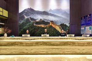 a group of three people sitting at a table with laptops at Atour Hotel Huaxiang Tiantan Hospital in Beijing