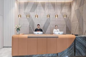 two people sitting at a table with their laptops at Atour Hotel Hangzhou West Lake Wulin Plaza North Jianguo Road in Hangzhou
