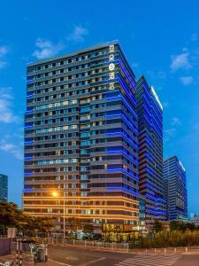 廈門市にあるAtour S Hotel Xiamen Cross-Strait Financial Centerの時計付きの高層ビル