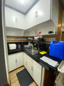 uma cozinha com armários brancos e um lavatório em Casa Valle Verde - Unit 46A em Baguio