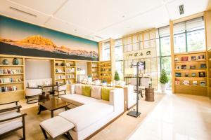 un soggiorno con divano bianco e librerie di Atour Hotel Chengdu High-Tech a Chengdu