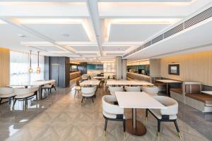 Un restaurante con mesas y sillas en una sala. en Atour Hotel Guangzhou Zhongcun Hanxi Changlong Metro Station, en Guangzhou