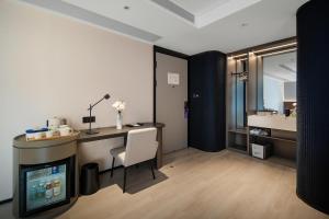 a room with a desk and a television and a bathroom at Atour Light Hotel Chongqing Yuzhong Daping Metro Station in Chongqing