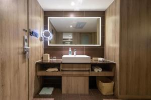 een badkamer met een wastafel en een spiegel bij Atour Hotel Guangzhou Avenue Tianhe Sports Center in Guangzhou