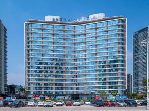 a tall building with cars parked in a parking lot at Atour Hotel Foshan Shunde Happy Coast in Shunde