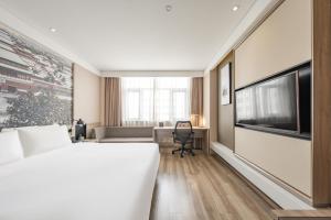 um quarto de hotel com uma cama grande e uma secretária em Atour Hotel Olympic Sports Center Bird's Nest em Pequim