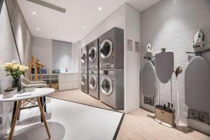 a laundry room with four washer and dryer machines at Atour Hotel Zhijiang Bridge in Hangzhou