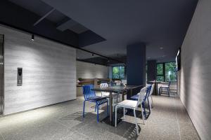 杭州的住宿－杭州西湖湖滨浣纱路轻居酒店，一间配备有蓝色椅子和桌子的用餐室