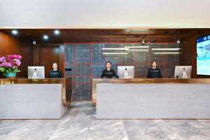 a group of people sitting at a reception desk at Atour Hotel Beijing Drum Tower in Beijing