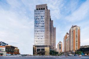 a tall building with a clock on it in a city at Atour Hotel Hangzhou West Lake Wulin Plaza North Jianguo Road in Hangzhou