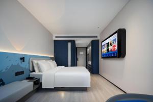 een hotelkamer met een bed en een flatscreen-tv bij Atour Light Hotel Guangzhou East Fuhua Road Panyu Plaza in Guangzhou