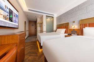 DaxingにあるAtour X Hotel Beijing Daxing Airport Wildlife Parkのベッド2台、薄型テレビが備わるホテルルームです。