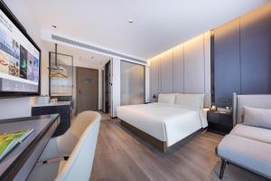 a hotel room with a bed and a tv at Atour Hotel Kunming Xiaokang Avenue in Kunming