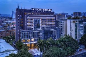ein großes Gebäude mit einem Hotelschild darüber in der Unterkunft Atour Hotel Guangzhou Panyu City Bridge in Guangzhou