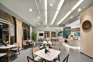 a restaurant with tables and chairs and a kitchen at Atour Hotel Kunming Dianchi Park 1903 in Kunming