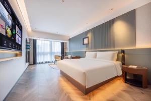 een slaapkamer met een groot wit bed in een kamer bij Atour S Hotel Shenzhen Luohu Clams in Shenzhen