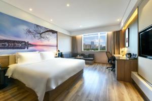 Atour Hotel Huaxiang Tiantan Hospital في بكين: غرفة فندقية بسرير ونافذة كبيرة