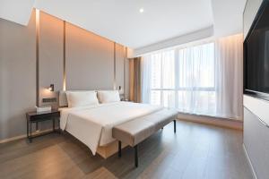 una camera da letto con un letto bianco e una grande finestra di Atour Hotel Beijing North Chaoyang Road Changyingtian Street a Pechino Altre 22 foto