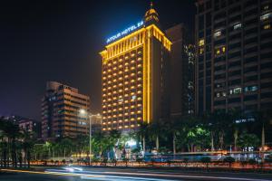 een verlicht gebouw in een stad 's nachts bij Atour Hotel Zhanjiang Renmin Avenue Dingsheng Plaza in Zhanjiang