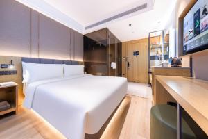 a bedroom with a large white bed and a kitchen at Atour X Hotel Beijing Majiabao Subway Station in Beijing