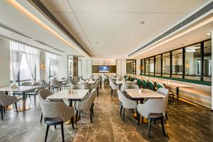 a restaurant with tables and chairs and windows at Atour Hotel Dongguan Humen Avenue in Dongguan