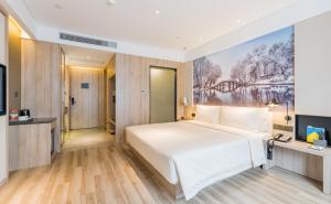 a hotel room with a bed and a television at Atour Hotel Hangzhou Zhuantang Songcheng Academy of Fine Arts in Hangzhou