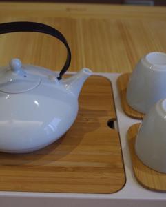 biały dzbanek do herbaty i filiżankę na stole w obiekcie Atour Hotel Xi'an Xiaozhai Petroleum University w mieście Xi'an