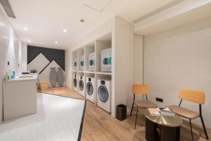 a laundry room with four washer and dryer machines at Atour Hotel Shanghai Caohejing in Shanghai +42 photos