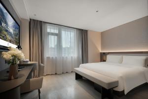 重慶市にあるAtour Light Hotel Chongqing Yuzhong Daping Metro Stationの大きなベッドと窓が備わるホテルルームです。