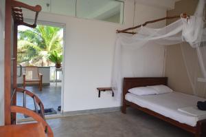 Voodi või voodid majutusasutuse The Stables Oceanfront Hotel Midigama toas