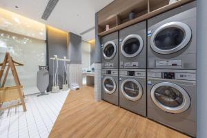 a laundry room with three washing machines in it at Atour Hotel Zhongshan Nantou Haiya Colorful City in Zhongshan