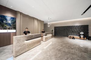a lobby with two men sitting at reception desks at Atour Hotel Chengdu Dujiangyan Darong City in Dujiangyan